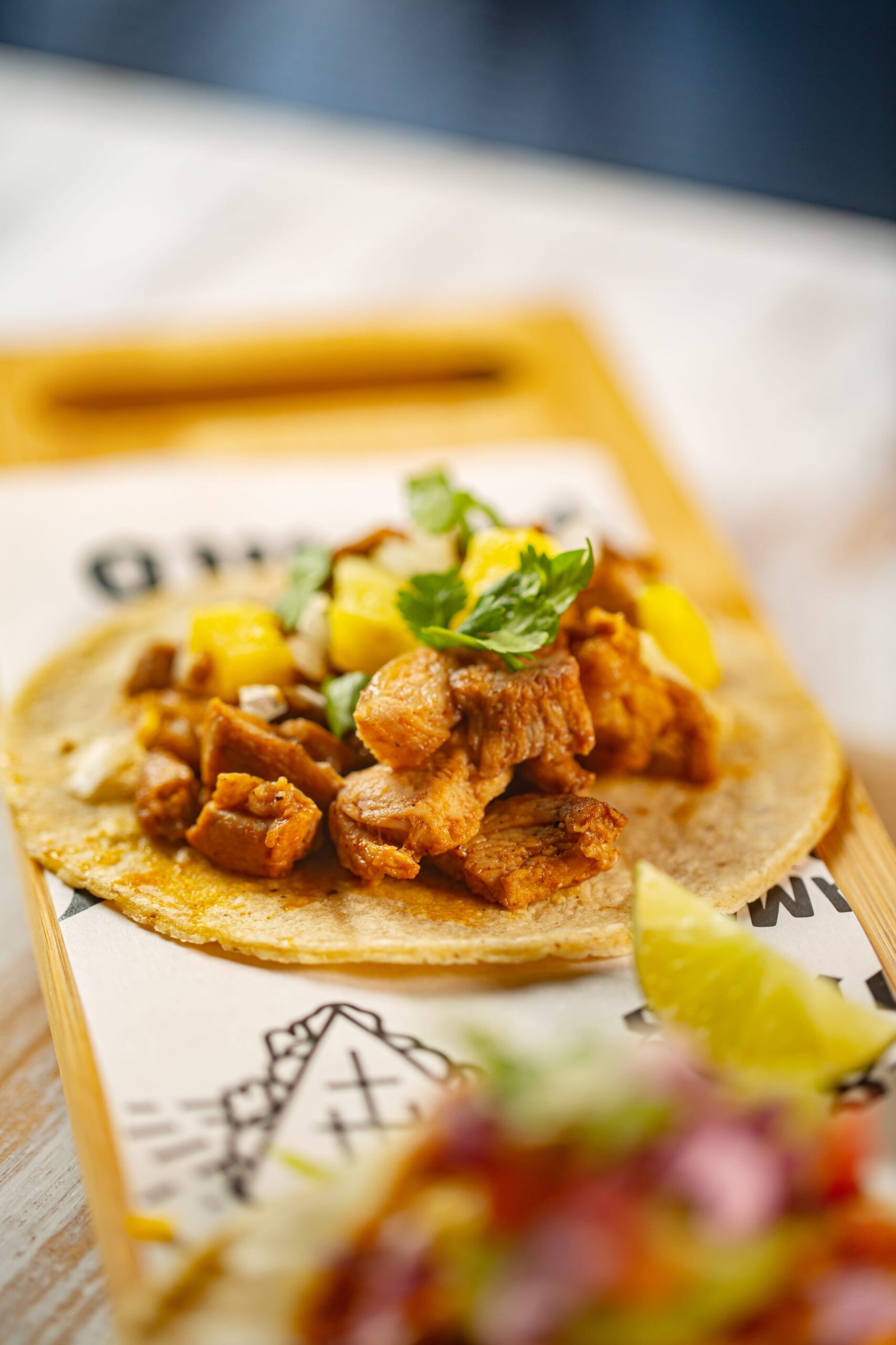 A freshly prepared street taco topped with seasoned meat and pineapple